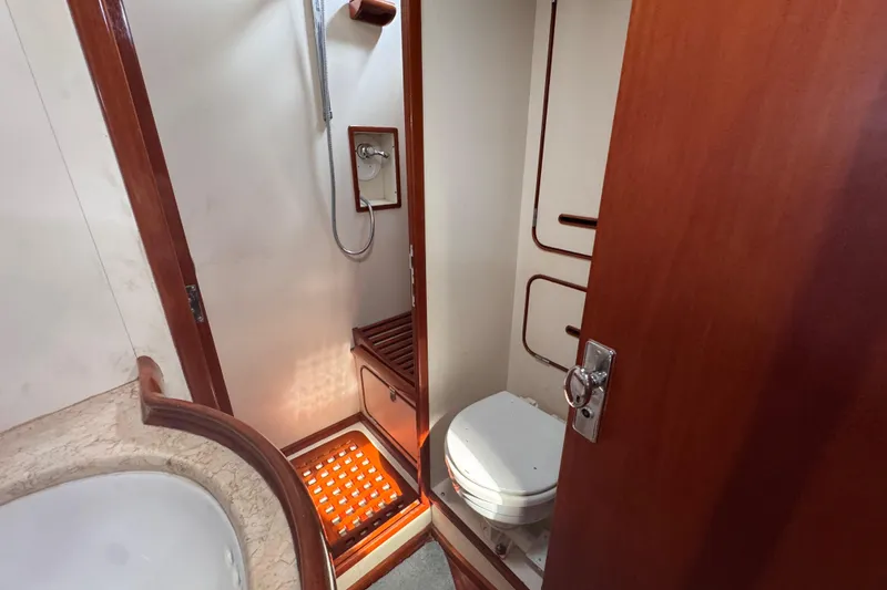Slide: The Image of 1989 Little Harbor Sloop 58' bathroom with shower and toilet, featuring wooden accents. - 85