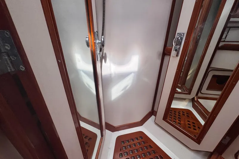 Slide: The Image of 1989 Little Harbor Sloop 58' interior with wooden accents and mirrored surfaces. - 76