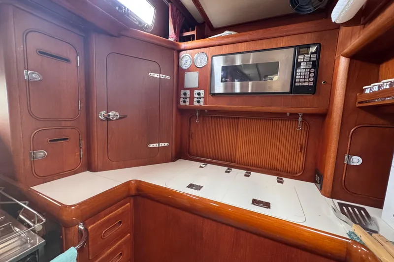 Slide: The Image of Wooden interior of 1989 Little Harbor Sloop 58' with microwave and storage cabinets. - 58
