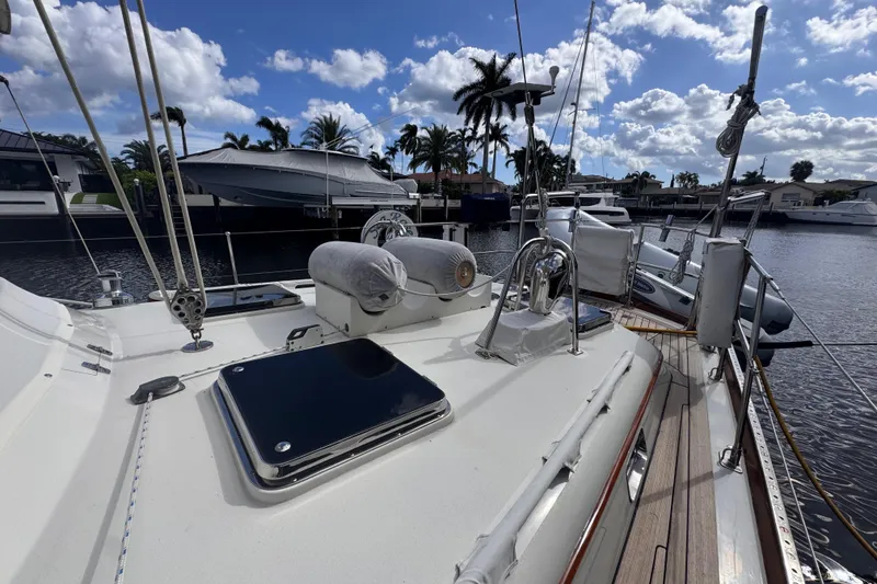 Slide: The Image of 1989 Little Harbor Sloop 58' yacht deck with marina view, clear sky, and palm trees. - 14