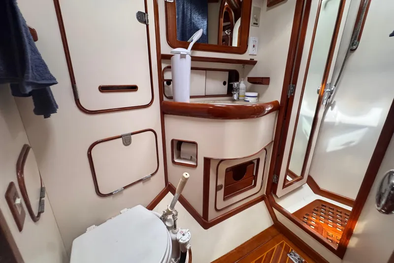 Slide: The Image of 1989 Little Harbor Sloop 58' bathroom with wooden accents and compact design. - 75