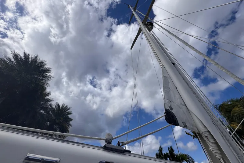 Slide: The Image of 1989 Little Harbor Sloop sailboat mast against cloudy sky and palm trees. - 32