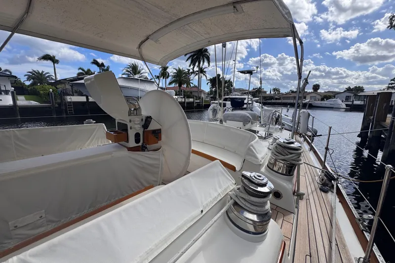 Slide: The Image of 1989 Little Harbor Sloop 58' yacht docked, featuring spacious deck and covered seating area. - 11