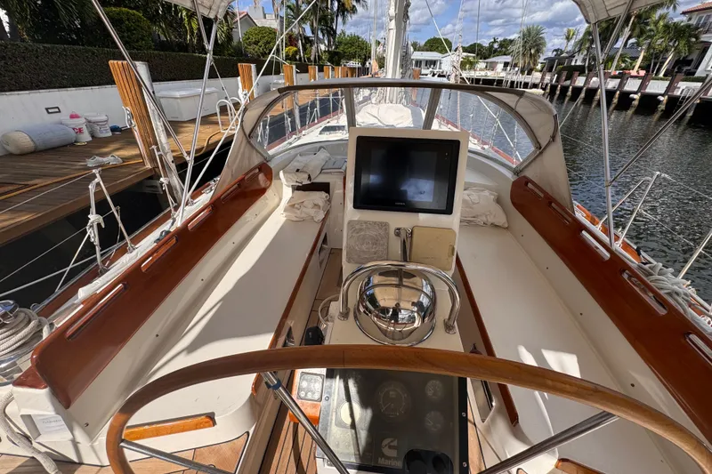 Slide: The Image of 1989 Little Harbor Sloop 58' cockpit with steering wheel, navigation equipment, and wooden accents. - 98