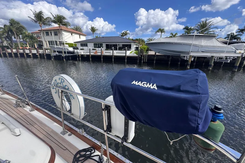 Slide: The Image of 1989 Little Harbor Sloop - 58' docked near waterfront homes, clear sky, and palm trees. - 18