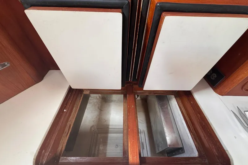 Slide: The Image of Interior view of 1989 Little Harbor Sloop 58' with wooden cabinetry and storage compartments. - 63