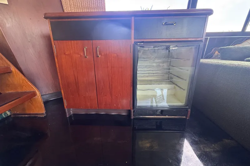 Slide: The Image of 1989 Ocean Yachts 48 Motor Yacht interior with wooden cabinet and glass-front mini fridge. - 61