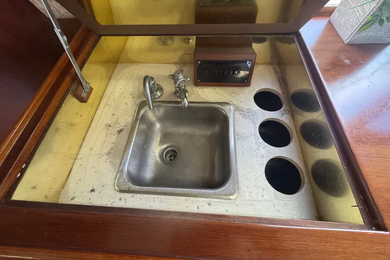 Slide: The Image of 1989 Ocean Yachts 48 Motor Yacht sink area with wooden cabinetry and mirrored backsplash. - 71