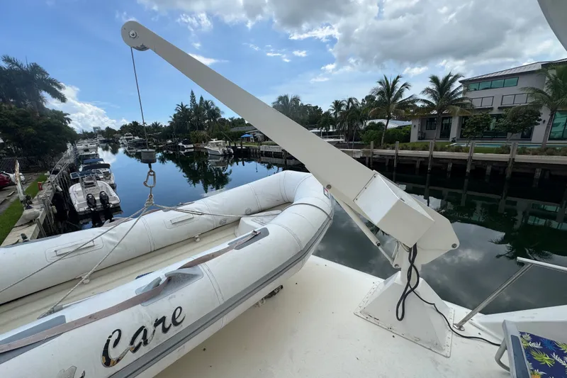 Slide: The Image of 1989 Ocean Yachts 48 Motor Yacht with dinghy on deck, docked by a canal. - 110
