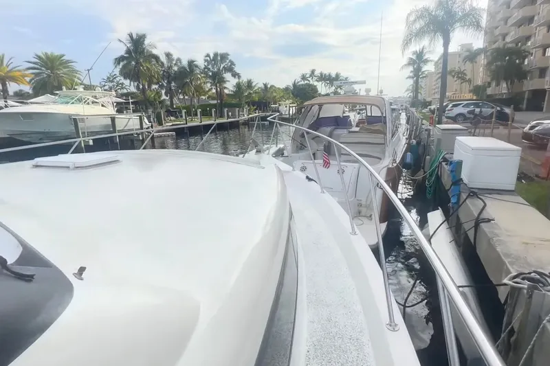 Slide: The Image of Eine weiße Yacht liegt an einem Dock, umgeben von Palmen und anderen Booten. - 7