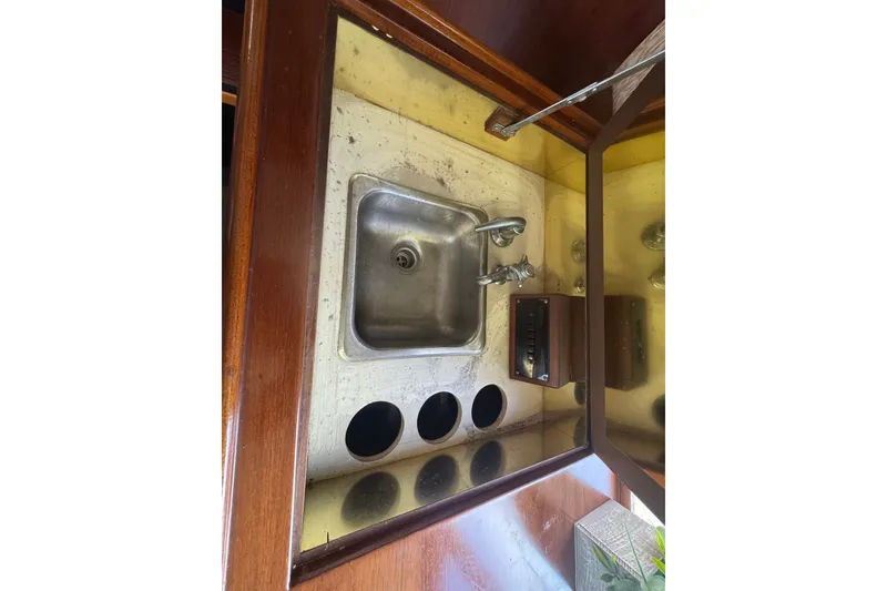 Slide: The Image of 1989 Ocean Yachts 48 Motor Yacht sink area with wooden cabinetry and mirrored backsplash. - 62
