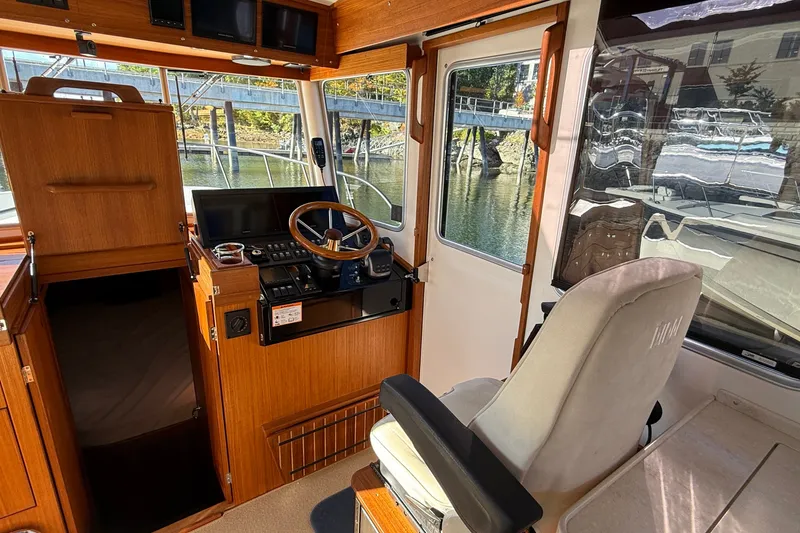 Slide: The Image of 2024 Targa 37 boat interior with wooden helm, steering wheel, and navigation equipment. - 26