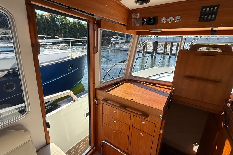 Slide: The Image of Interior view of 2024 Targa 37 boat, showcasing wooden cabinetry and marina backdrop. - 55
