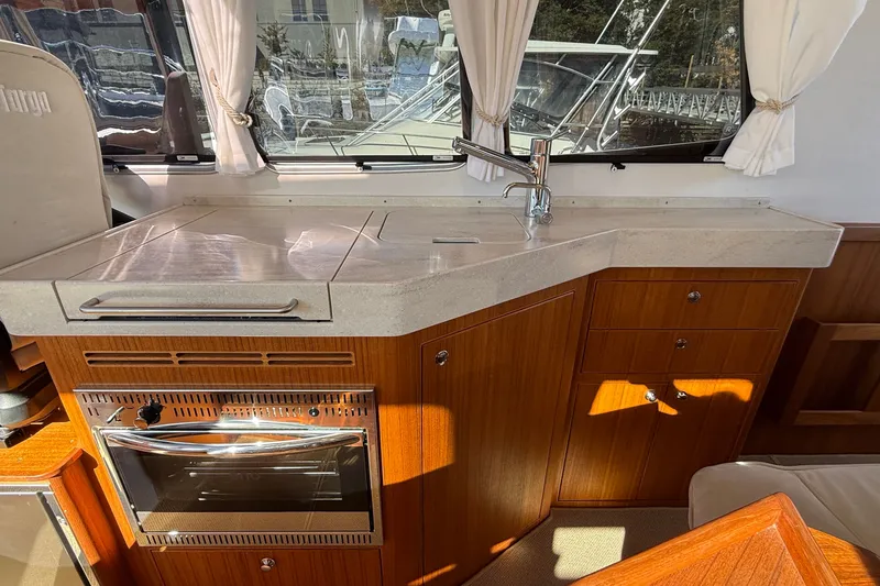 Slide: The Image of Modern kitchen area in 2024 Targa 37 boat with wooden cabinetry and stainless steel oven. - 18