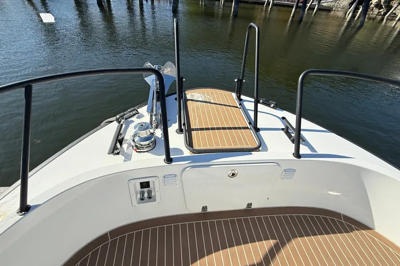 Slide: The Image of 2024 Targa 37 boat deck with railing and anchor, docked on calm water. - 57
