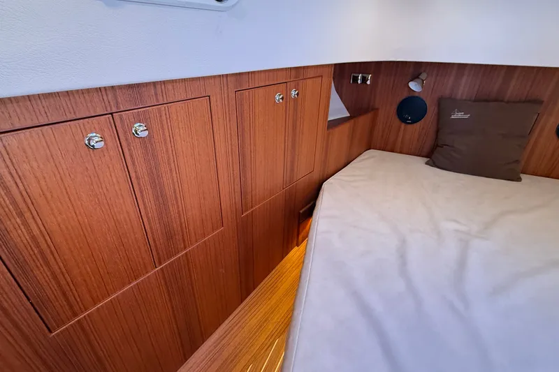 Slide: The Image of 2024 Targa 37 cabin interior with wooden cabinetry and cozy bedding. - 44