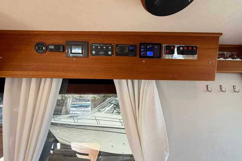 Slide: The Image of Control panel inside 2024 Targa 37 boat, featuring switches and displays above a window. - 14
