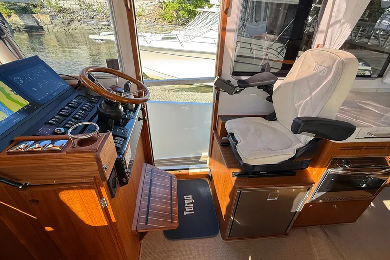 Slide: The Image of 2024 Targa 37 helm with wooden steering wheel, modern controls, and comfortable captain's chair. - 39