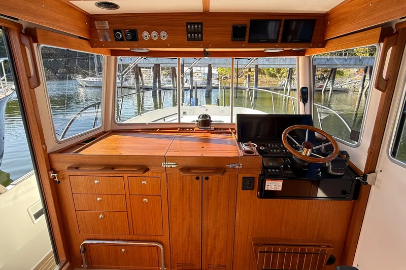 Slide: The Image of 2024 Targa 37 boat interior with wooden helm, steering wheel, and navigation equipment. - 28
