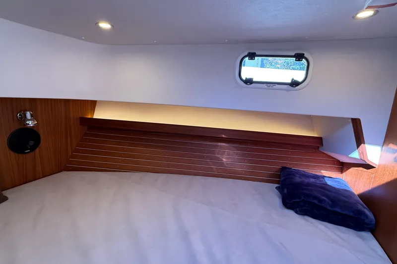 Slide: The Image of Cozy cabin interior of 2024 Targa 37 boat with wooden accents and a small window. - 47