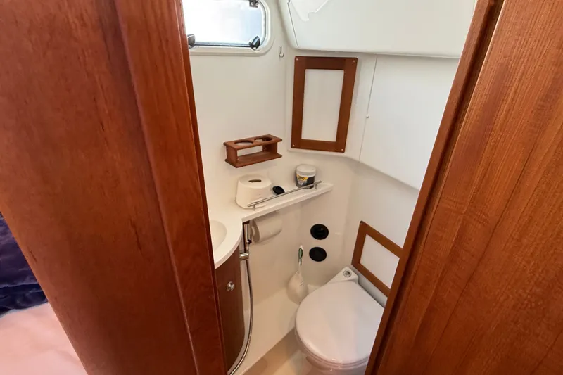 Slide: The Image of 2024 Targa 37 yacht bathroom with wooden accents and compact design. - 49