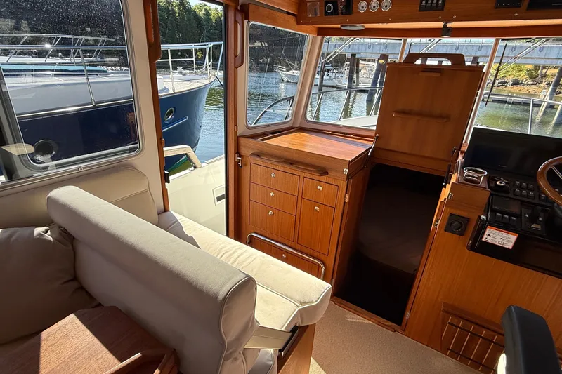 Slide: The Image of Interior of 2024 Targa 37 boat with wooden cabinetry and seating, docked at marina. - 25