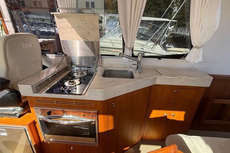 Slide: The Image of Interior of 2024 Targa 37 yacht featuring a compact kitchen with stove and sink. - 19