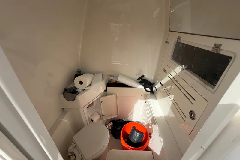 Slide: The Image of Interior of 2014 Jupiter 34 FS boat showing compact bathroom with toilet and storage. - 40