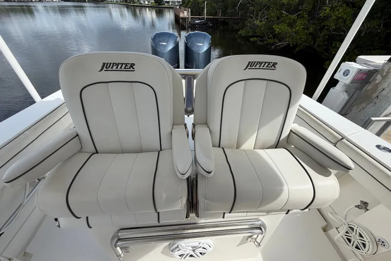 Slide: The Image of Two white cushioned seats on a 2014 Jupiter 34 FS boat deck. - 34