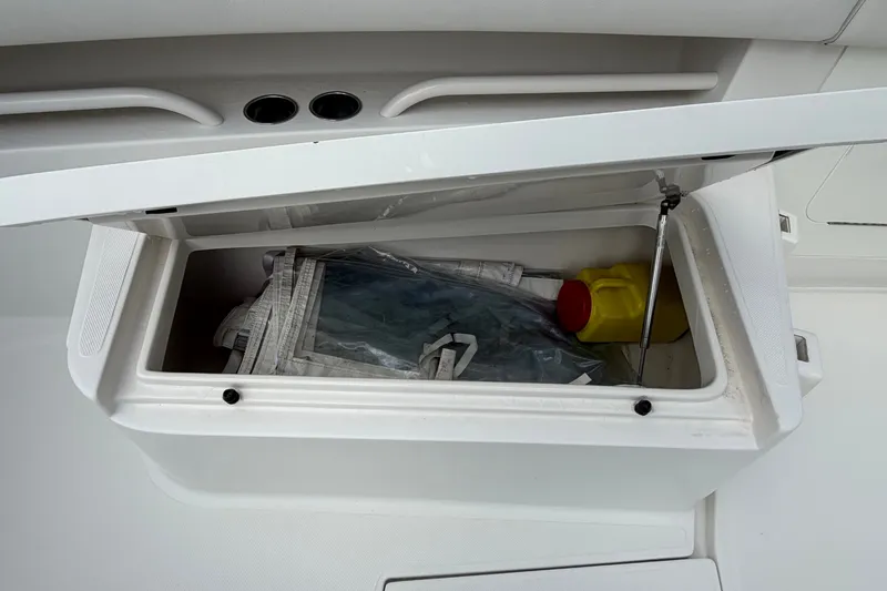 Slide: The Image of Open storage compartment on a 2014 Jupiter 34 FS boat, containing various items. - 59