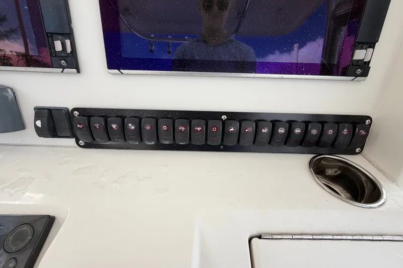 Slide: The Image of Control panel of a 2014 Jupiter 34 FS boat with multiple switches and displays. - 25