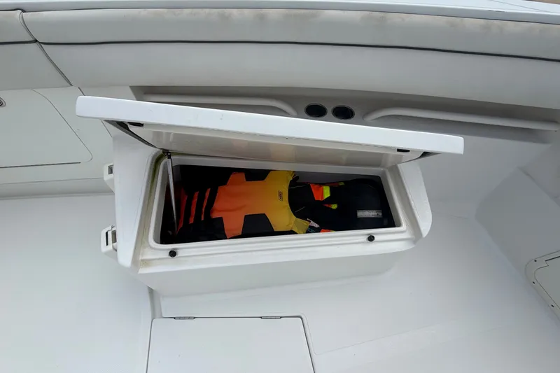 Slide: The Image of Open storage compartment on 2014 Jupiter 34 FS boat with life jackets inside. - 57