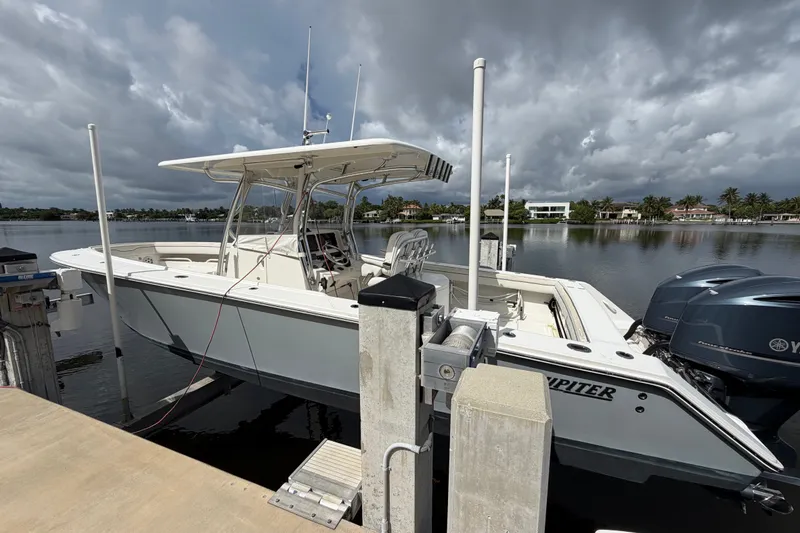 Slide: The Image of 2014 Jupiter 34 FS boat docked by a calm waterfront under cloudy skies. - 3