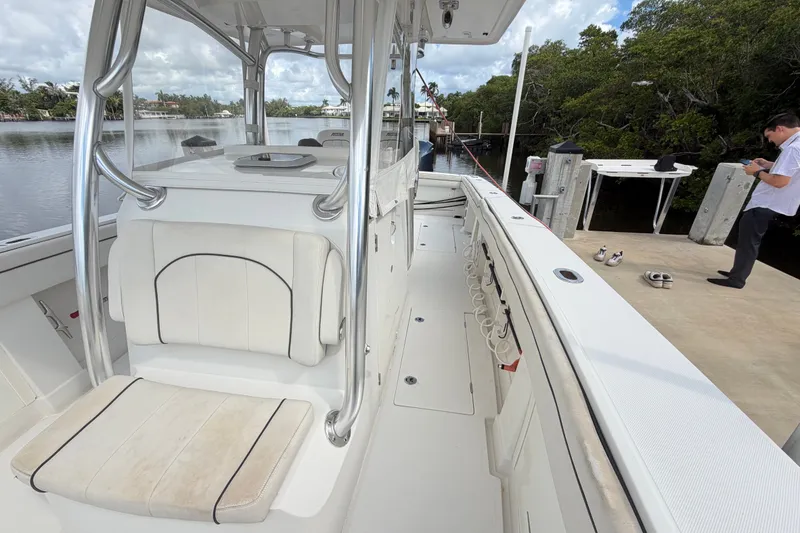Slide: The Image of 2014 Jupiter 34 FS boat docked by a serene waterfront with lush greenery. - 48
