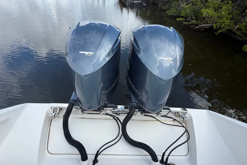 Slide: The Image of Twin outboard motors on a 2014 Jupiter 34 FS boat, docked on calm water. - 5