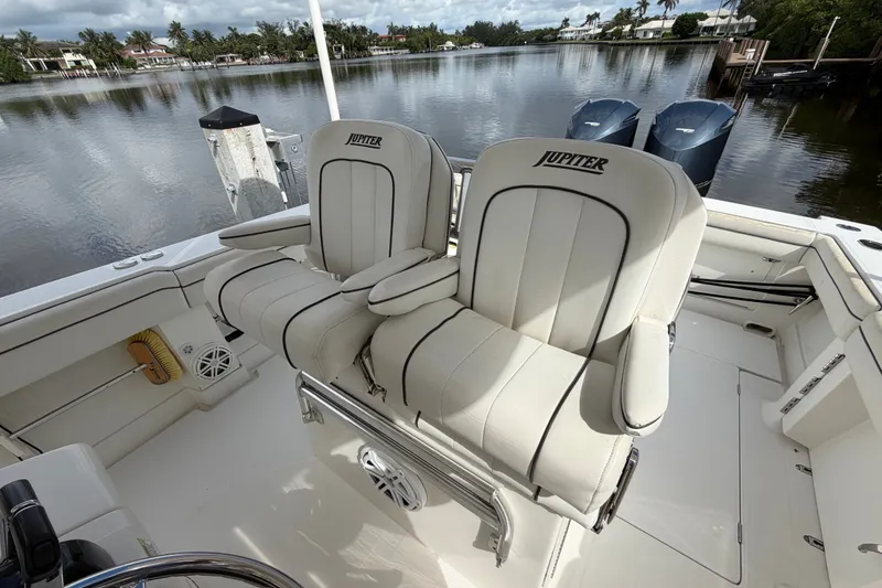 Slide: The Image of 2014 Jupiter 34 FS boat with dual seats, docked by a serene waterfront. - 33