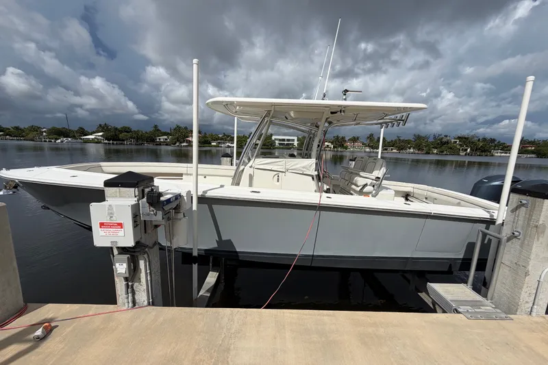 Slide: The Image of 2014 Jupiter 34 FS boat docked by a serene waterfront under cloudy skies. - 2