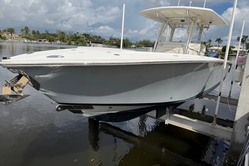 Slide: The Image of 2014 Jupiter 34 FS boat docked on a lift, with a scenic waterfront background. - 1