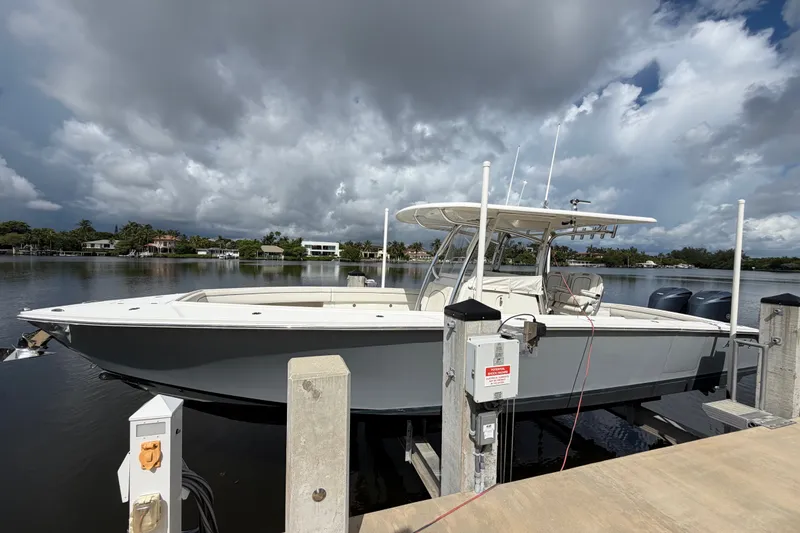 The Image of 2014 Jupiter 34 FS boat docked by a scenic waterfront under cloudy skies. - 0