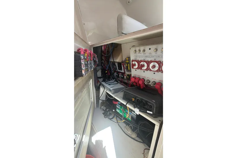Slide: The Image of Electrical panel inside 2015 Jupiter 34 FS boat, featuring wiring and battery switches. - 14