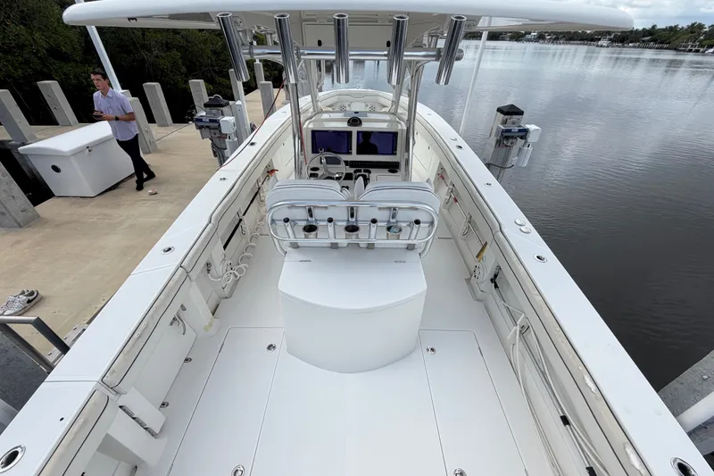 Slide: The Image of 2014 Jupiter 34 FS boat docked by a calm waterfront, featuring a spacious deck and modern controls. - 17