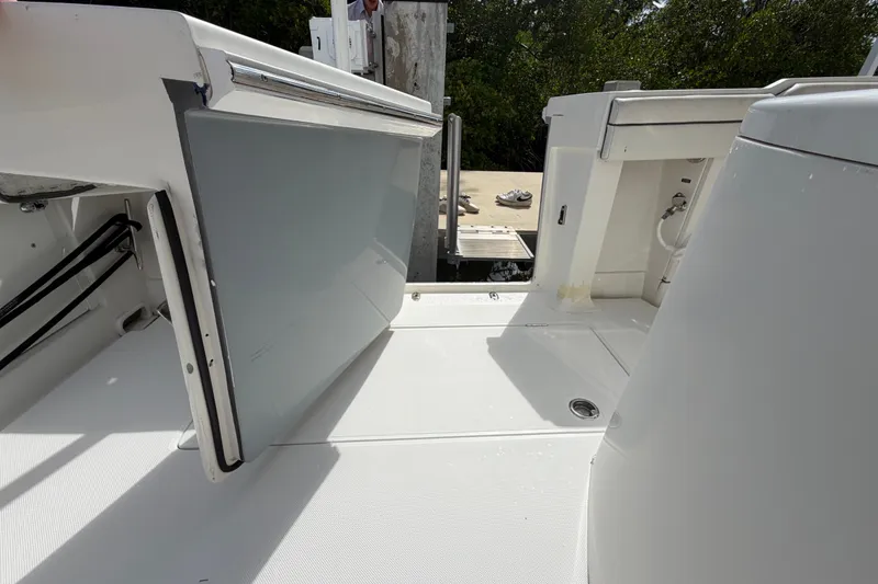Slide: The Image of 2014 Jupiter 34 FS boat interior with open storage compartment and clean white deck. - 13