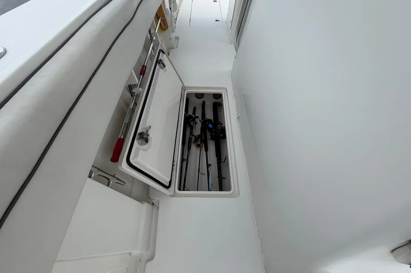 Slide: The Image of 2014 Jupiter 34 FS boat with open storage compartment holding fishing rods. - 50