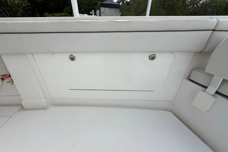 Slide: The Image of 2014 Jupiter 34 FS boat interior storage compartment with white cushioned seating. - 45