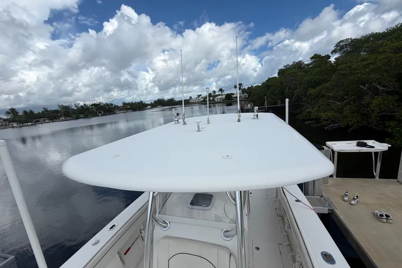 Slide: The Image of 2014 Jupiter 34 FS boat docked by a serene waterfront under a cloudy sky. - 79