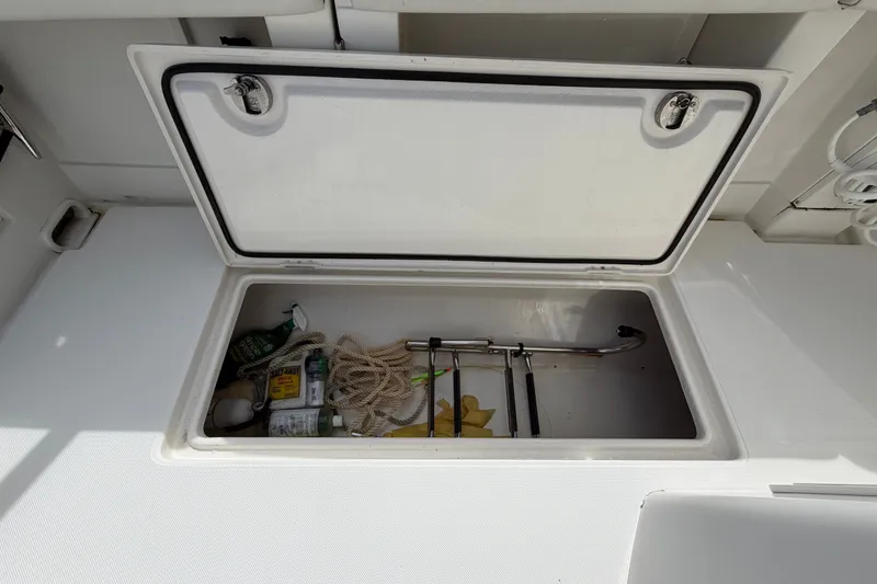 Slide: The Image of Open storage compartment on 2014 Jupiter 34 FS boat with various items inside. - 42
