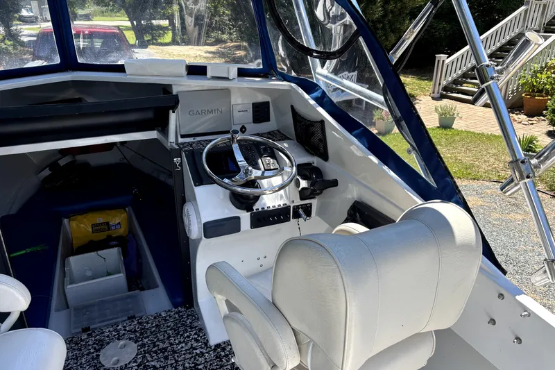 Slide: The Image of Interior of a 1978 B&D 24 Cuddy boat with steering wheel and Garmin navigation system. - 5