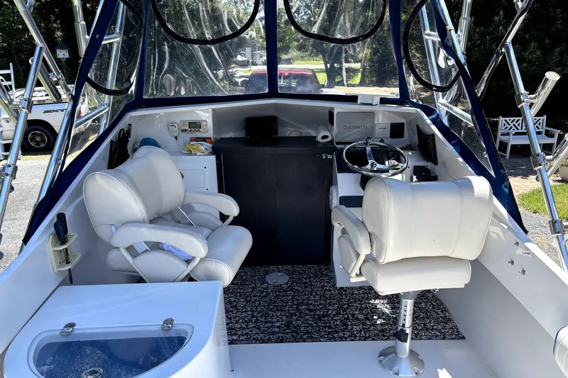 Slide: The Image of Interior of a 1978 B&D 24 Cuddy boat with white seating and steering console. - 3
