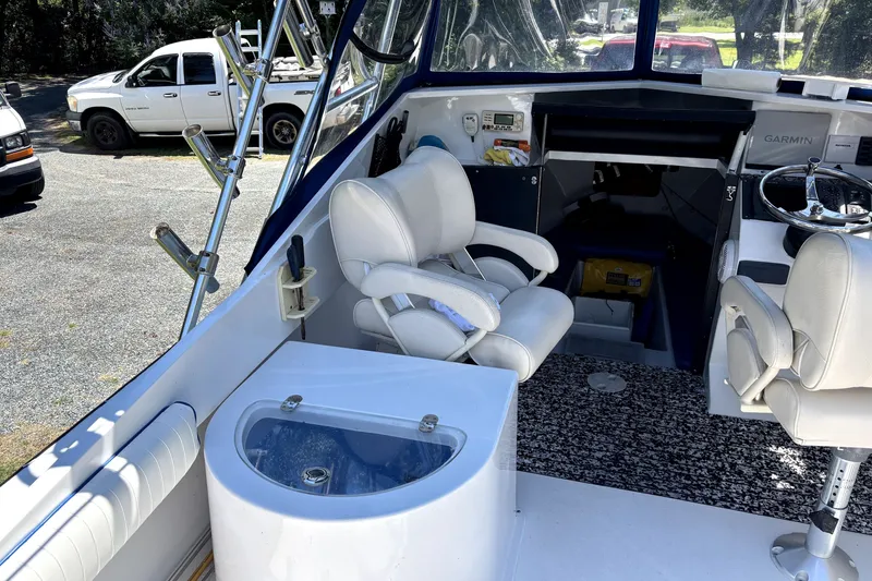 Slide: The Image of 1978 B&D 24 Cuddy boat interior with white seating and steering wheel. - 4