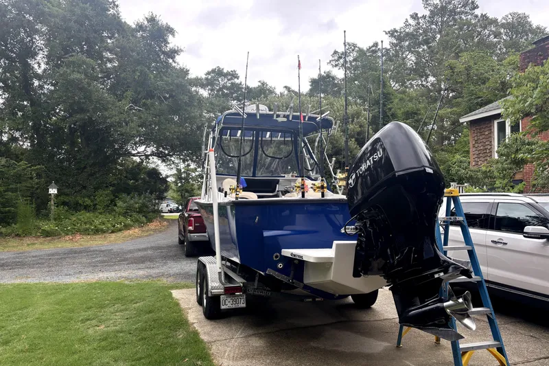 Slide: The Image of 1978 B&D 24 Cuddy boat on trailer with Tohatsu outboard motor in driveway. - 2